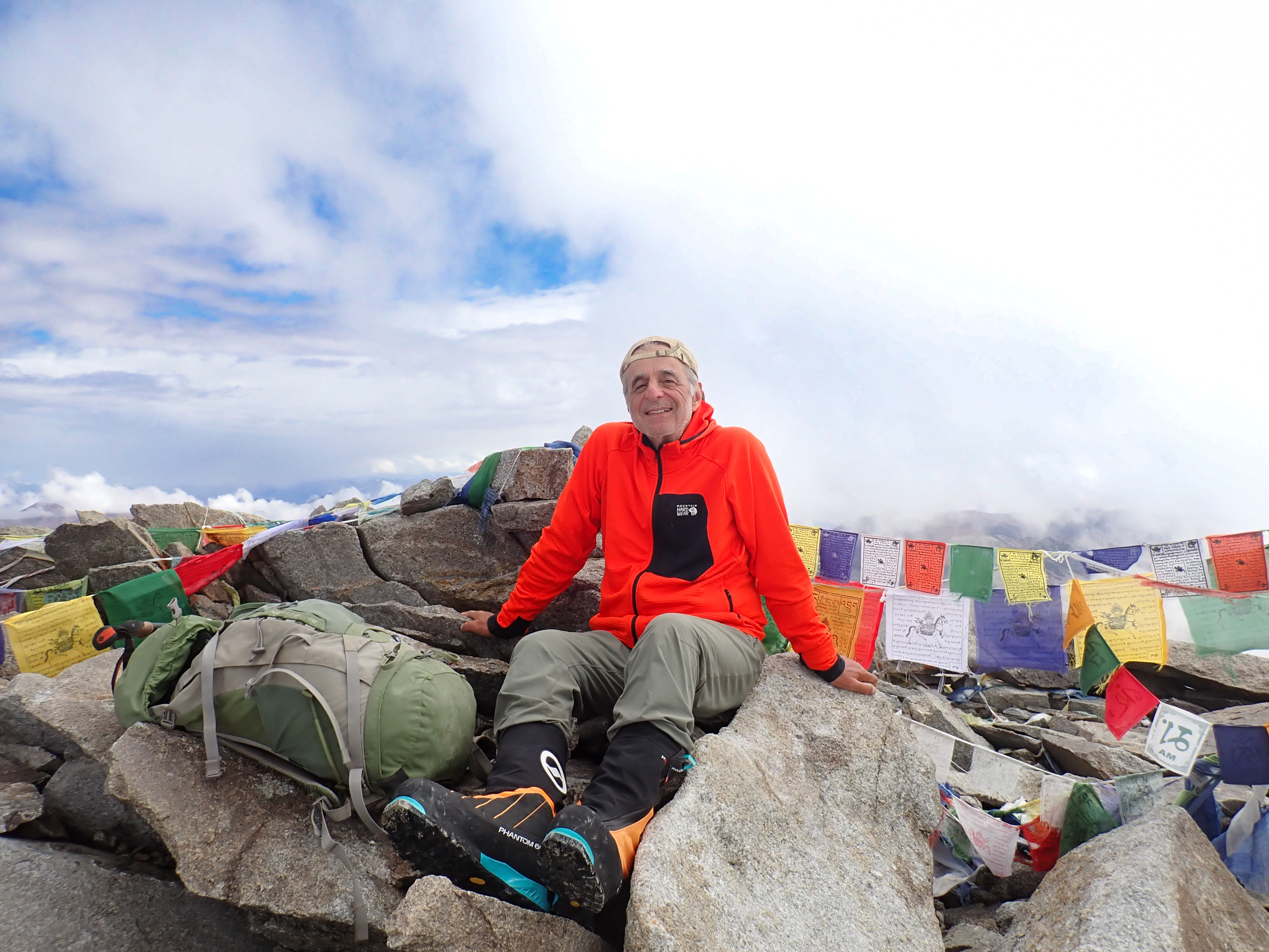Leo Rub at mountain summit with prayer flags